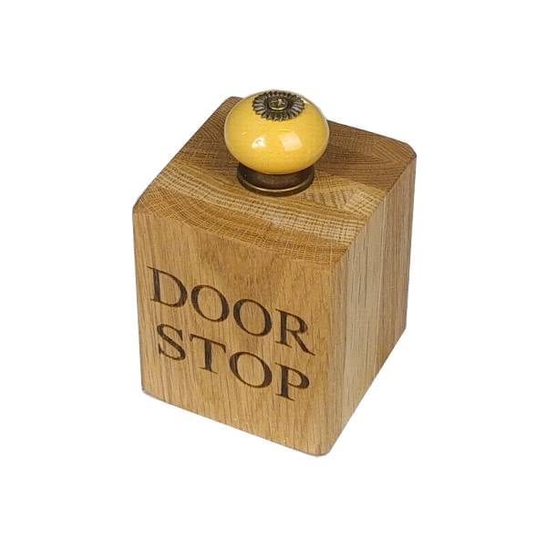 Small solid oak doorstop with yellow door knob